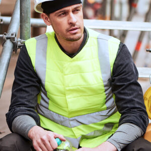 Construction worker wearing an SX3 cooling vest with reflectors from E.COOLINE in signal yellow