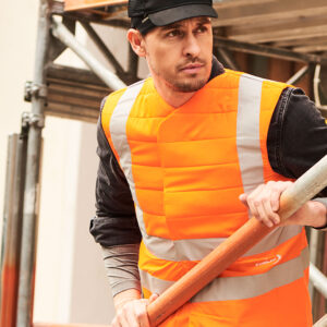 Construction worker wearing an SX3 cooling vest with reflectors from E.COOLINE in signal orange