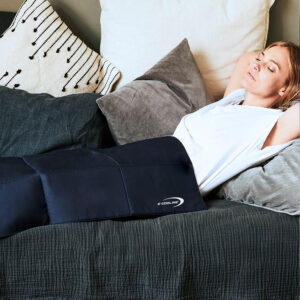 Woman lying on sofa with Repower Cooling Blanket, blue