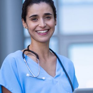 Krankenschwester mit Arbeitskleidung lächel mit E.COOLINE Kühlkleidung unter der Berufskleidung